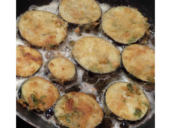 Fried eggplant slices in a pan, golden brown and crispy. They float in hot oil and are seasoned with herbs., &copy; Kultweine-Kochwelten-Kunst&uuml;cke - Kochschule Sonja Lenz