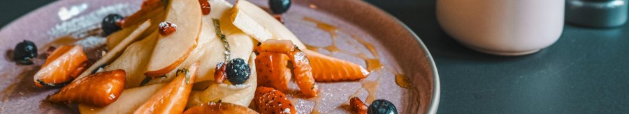 Ein Teller mit geschnittenen Fr&uuml;chten, Beeren und Sirup. Daneben eine Zuckerdose und ein Salzstreuer auf einem dunklen Tisch., &copy; Lupin, Stuttgart