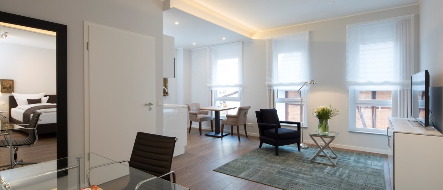 Bright executive suite with modern design, glass desk, cozy sitting area, large window and stylish decoration., © Hotel LOGIS Bright executive suite with modern design, glass desk, cozy sitting area, large window and stylish decoration., © Hotel LOGIS