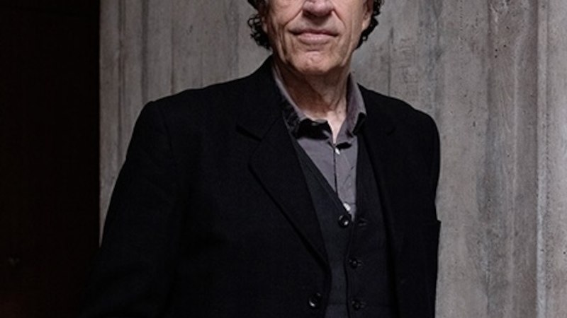 Ein Mann in dunkler Kleidung steht vor einer Betonwand und blickt in die Kamera., © Renitenztheater Stuttgart e.V. Ein Mann in dunkler Kleidung steht vor einer Betonwand und blickt in die Kamera., © Renitenztheater Stuttgart e.V.