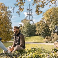 Zwei Personen sitzen im Höhenpark Killesberg, umgeben von Herbstbäumen. Im Hintergrund ist der Killesbergturm zu sehen, neben einer Pferdestatue., © Stuttgart-Marketing GmbH, Sarah Schmid Zwei Personen sitzen im Höhenpark Killesberg, umgeben von Herbstbäumen. Im Hintergrund ist der Killesbergturm zu sehen, neben einer Pferdestatue., © Stuttgart-Marketing GmbH, Sarah Schmid