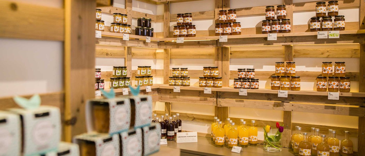 Regale mit Marmeladengläsern und Saftflaschen in einem Laden. Die Produkte sind ordentlich angeordnet und mit Etiketten versehen., © Benjamin Stollenberg