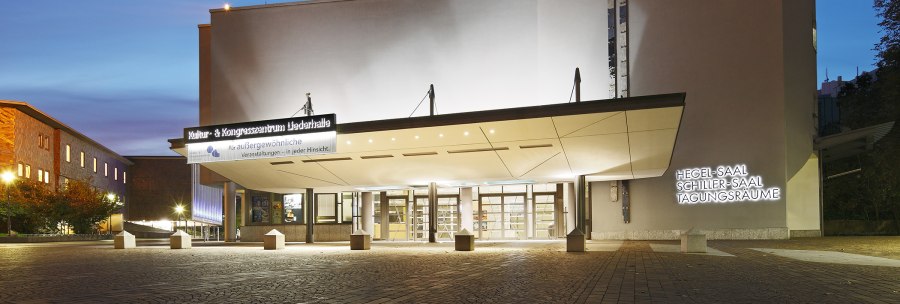 Eingang der Liederhalle Stuttgart bei D&auml;mmerung, beleuchtet mit Schildern f&uuml;r Hegel-Saal, Schiller-Saal und Tagungsr&auml;ume., &copy; Kultur- und Kongresszentrum Liederhalle
