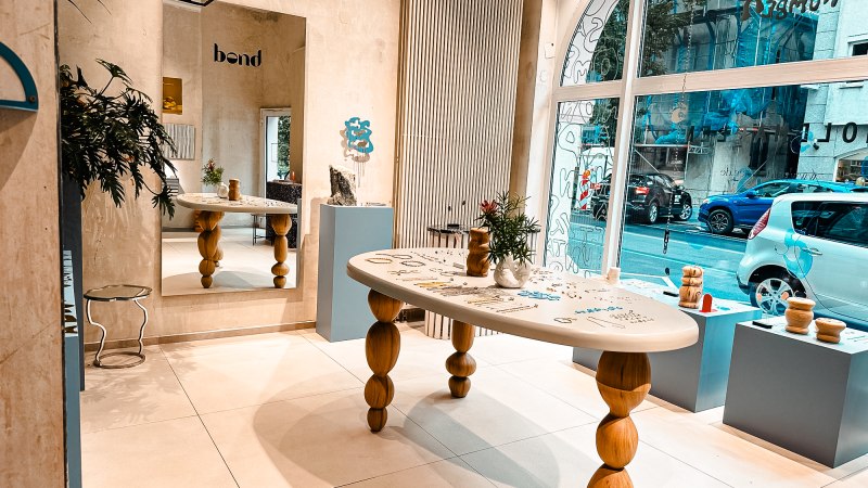 Modernes Studio mit Holztisch, Spiegel und Dekorationen. Große Fensterfront mit Blick auf die Straße. Pflanzen und Kunstobjekte als Dekoration., © Goldmarlen Modernes Studio mit Holztisch, Spiegel und Dekorationen. Große Fensterfront mit Blick auf die Straße. Pflanzen und Kunstobjekte als Dekoration., © Goldmarlen