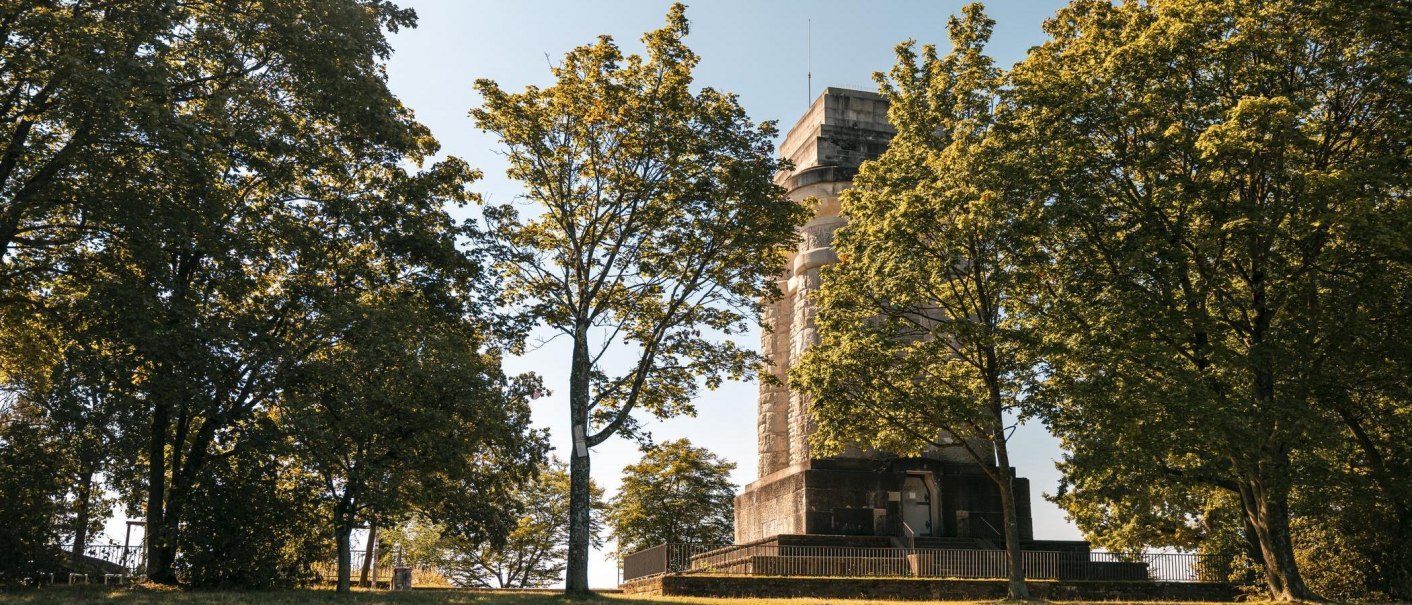 Der Bismarckturm steht hinter Bäumen im Sonnenlicht. Die Szenerie wirkt ruhig und idyllisch., © Stuttgart Marketing GmbH, Sarah Schmid Der Bismarckturm steht hinter Bäumen im Sonnenlicht. Die Szenerie wirkt ruhig und idyllisch., © Stuttgart Marketing GmbH, Sarah Schmid