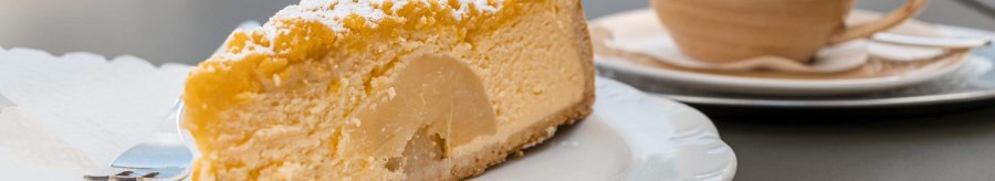 A slice of cake with powdered sugar on a plate, a cup of coffee next to it on a table in Caf&eacute; Schurr., &copy; SMG Stuttgart Marketing GmbH - Sarah Schmid