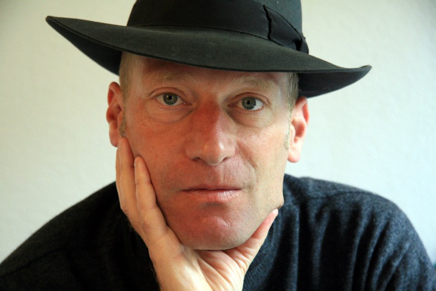 Ein Mann mit schwarzem Hut st&uuml;tzt nachdenklich sein Kinn auf die Hand. Er tr&auml;gt einen dunklen Pullover und blickt direkt in die Kamera., &copy; Foto: Yvonne Berardi