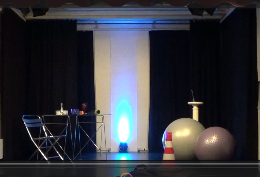 Ein Raum mit Tisch, Stuhl, Gymnastikb&auml;llen und einem Verkehrskegel, beleuchtet von blauem Licht., &copy; Dreigroschentheater