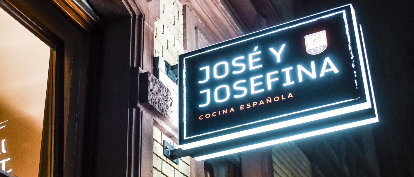 Leuchtschild mit der Aufschrift 'José y Josefina' und 'Cocina Española' an einer Gebäudewand., © Jose y Josefina, Stuttgart