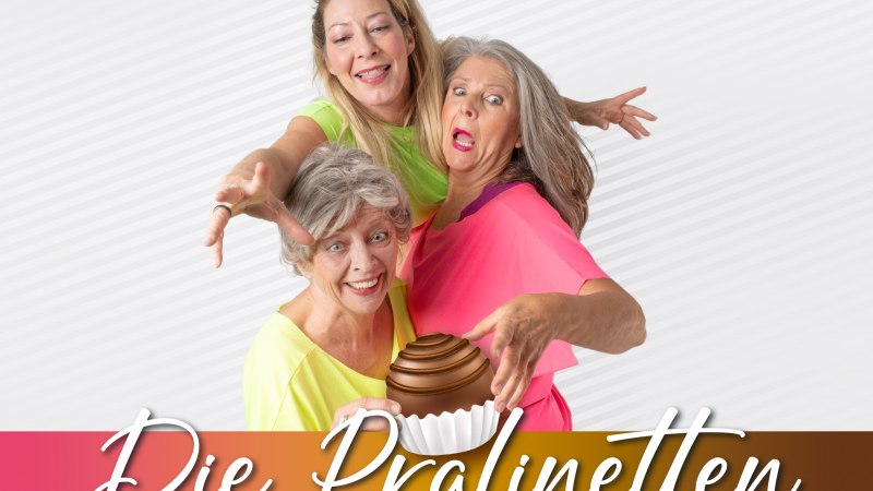 Drei Frauen in bunten Oberteilen posieren fr&ouml;hlich vor einem gestreiften Hintergrund. Der Schriftzug 'Die Pralinetten' ist am unteren Rand zu sehen., &copy; Friedrichsbau Variet&eacute;