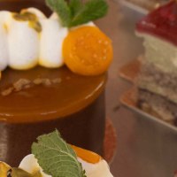 Close-up of artfully decorated cakes in a display case. Various toppings such as fruit and cream can be seen., &copy; SMG