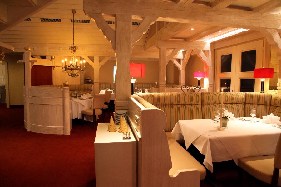 Elegant restaurant with wooden beams, red lamps and laid tables on red carpeting., © Hotel Fuchsen Elegant restaurant with wooden beams, red lamps and laid tables on red carpeting., © Hotel Fuchsen