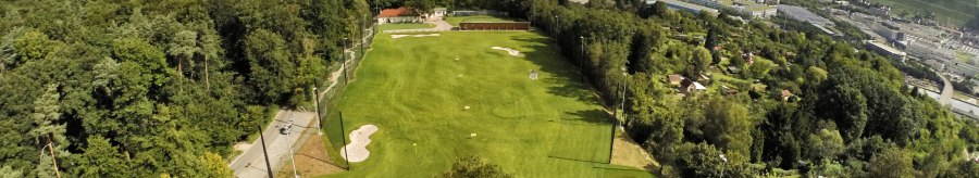 Luftaufnahme eines Golfplatzes in Stuttgart, umgeben von Bäumen und Hügeln, mit der Stadt im Hintergrund unter einem bewölkten Himmel., © GolfKultur Stuttgart