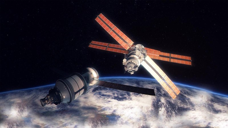 A space capsule approaches a space station in outer space, with the Earth in the background. The station has large solar panels., &copy; Planetarium Stuttgart