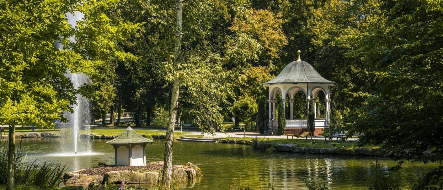 An idyllic park with a gazebo and a fountain in a pond, surrounded by lush greenery and trees., © SMG Stuttgart Marketing GmbH - Sarah Schmid An idyllic park with a gazebo and a fountain in a pond, surrounded by lush greenery and trees., © SMG Stuttgart Marketing GmbH - Sarah Schmid