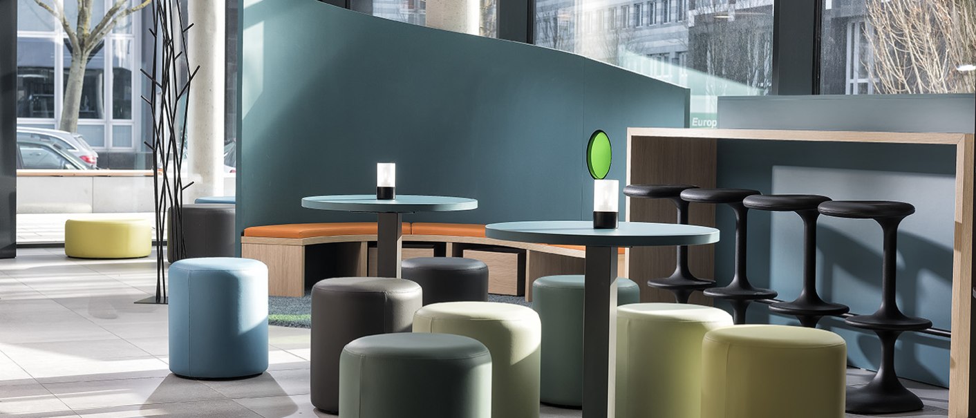 Moderne Empfangshalle mit bunten Sitzhockern, Tischen und Barhockern vor großen Fenstern. Helle, freundliche Atmosphäre mit stilvollem Design., © ibis Styles Stuttgart Vaihingen