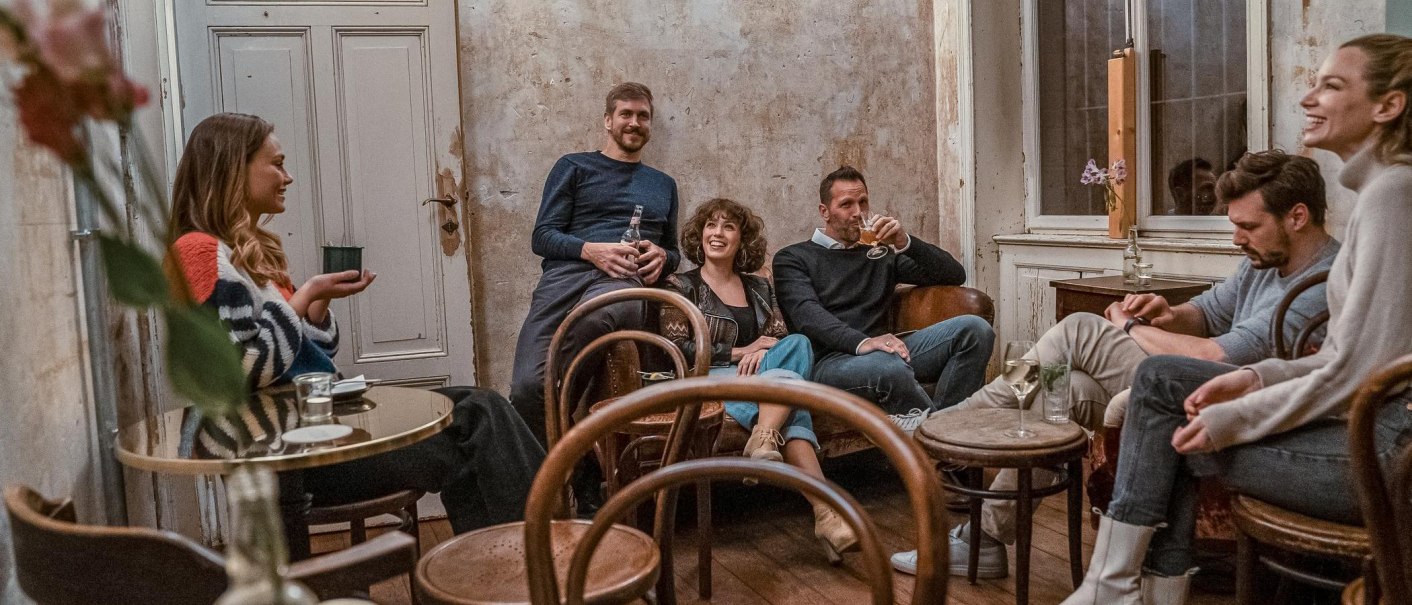 A group of six people sit in a cozy room with rustic furnishings and have a relaxed conversation., © SMG Stuttgart Marketing GmbH A group of six people sit in a cozy room with rustic furnishings and have a relaxed conversation., © SMG Stuttgart Marketing GmbH