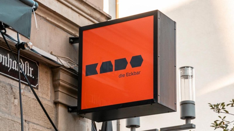 Ein leuchtend oranges Schild mit der Aufschrift 'Kado die Eckbar' h&auml;ngt an einer Hauswand in der Leonhardstra&szlig;e., &copy; Stuttgart-Marketing GmbH, Sarah Schmid