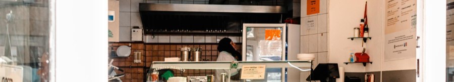 Ein Imbiss mit gelbem Schild 'Imbiss Beirut', leeren Tischen und einer Person hinter der Theke., &copy; SMG, Sarah Schmid