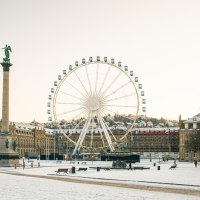 Winterlicher Schlossplatz in Stuttgart mit schneebedecktem Boden, einer hohen S&auml;ule und einem gro&szlig;en Riesenrad vor einem Schloss, im Hintergrund., &copy; Stuttgart-Marketing GmbH, Sarah Schmid