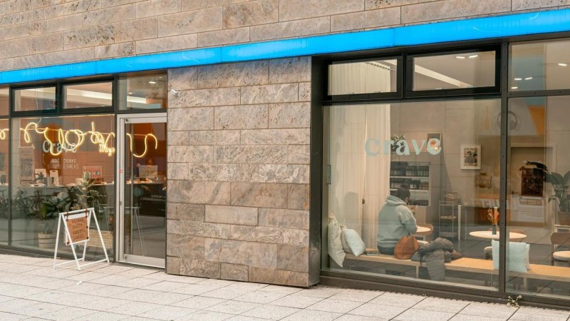 Gro&szlig;e Fensterfronten, die Blick auf das Caf&eacute; im Inneren freigeben: Holztische, wei&szlig;e Kissen., &copy; Stuttgart-Marketing GmbH, Sarah Schmid