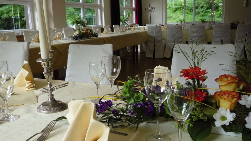 Festlich gedeckter Tisch im Römerhof Stuttgart mit Blumen, Kerzen und Gläsern, bereit für eine Veranstaltung., © Kulinarium und Römerhof Stuttgart