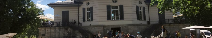 The Bärenschlössle in Stuttgart, surrounded by trees, with people relaxing and playing outside in the sunny weather., © SMG