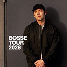 Ein Mann in dunkler Kleidung und Mütze steht vor einer Wand. Text: BOSSE TOUR 2026., © links im Bild Ein Mann in dunkler Kleidung und Mütze steht vor einer Wand. Text: BOSSE TOUR 2026., © links im Bild