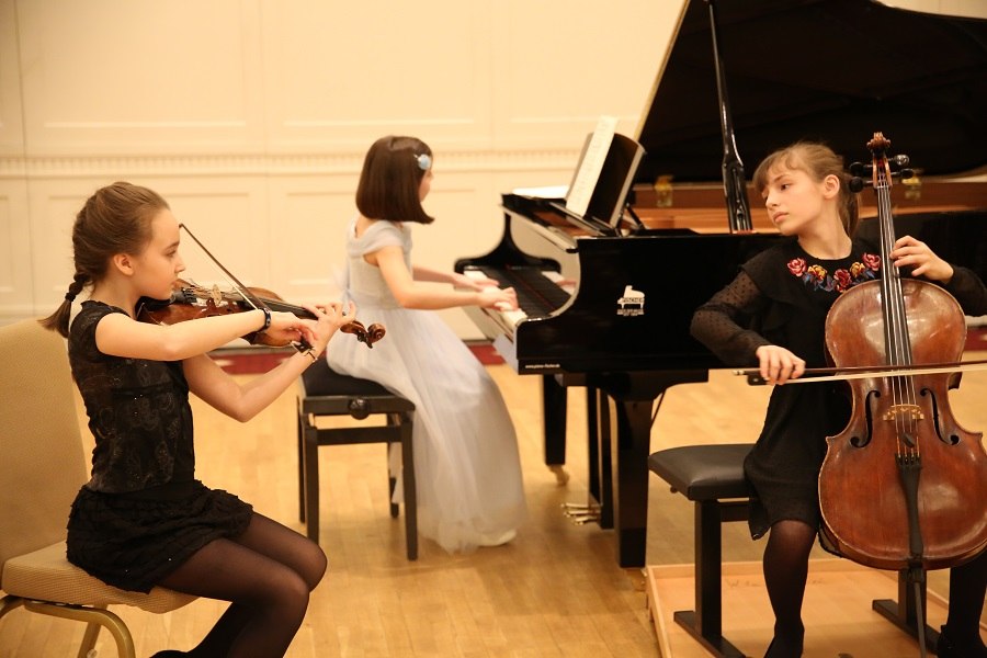 Drei junge Musikerinnen spielen Geige, Cello und Klavier bei einem Konzert im Le Meridién. Sie tragen elegante Kleider und konzentrieren sich auf ihre Instrumente., © Christian Steeneck Drei junge Musikerinnen spielen Geige, Cello und Klavier bei einem Konzert im Le Meridién. Sie tragen elegante Kleider und konzentrieren sich auf ihre Instrumente., © Christian Steeneck