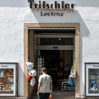 Gesch&auml;ftseingang von 'Tritschler Life Style' mit Schaufenstern und einem Mann, der hineingeht. Pl&uuml;schtiere h&auml;ngen am Eingang., &copy; Stuttgart-Marketing GmbH, Sarah Schmid