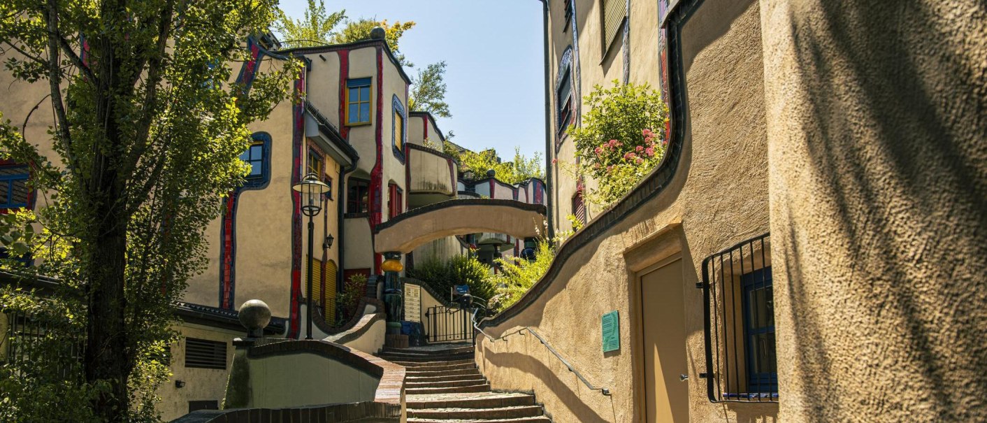 The Hundertwasser House in Plochingen showcases its distinctive, colorful, and undulating architecture, complete with lush greenery and winding paths., © SMG Stuttgart Marketing GmbH - Sarah Schmid The Hundertwasser House in Plochingen showcases its distinctive, colorful, and undulating architecture, complete with lush greenery and winding paths., © SMG Stuttgart Marketing GmbH - Sarah Schmid