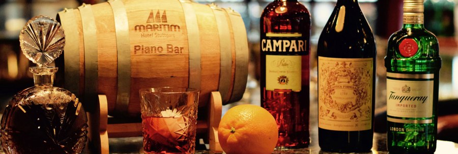 Eine elegante Bar mit einem Holzfass, verschiedenen Spirituosenflaschen und einem Glas mit Getr&auml;nk auf einer gl&auml;nzenden Theke., &copy; Maritim Hotels