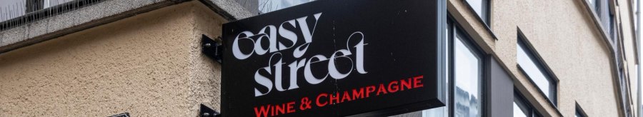 A sign with the words 'easy street Wine & Champagne' hangs on the wall of a building. A house number can be seen below it., &copy; Stuttgart-Marketing GmbH, Sarah Schmid