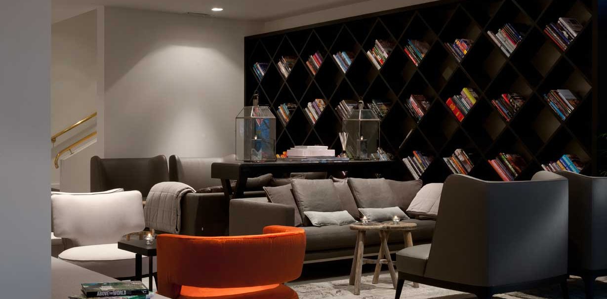Modern lobby with comfortable sofas, a large bookshelf and stylish decorations. Inviting atmosphere with subdued lighting., © Wyndham Stuttgart Airport Messe Modern lobby with comfortable sofas, a large bookshelf and stylish decorations. Inviting atmosphere with subdued lighting., © Wyndham Stuttgart Airport Messe