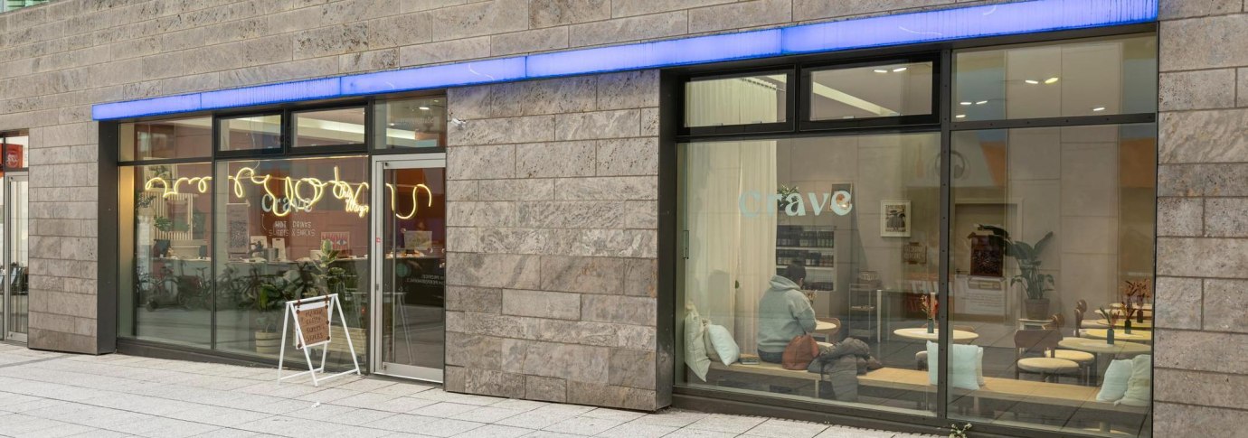 Gro&szlig;e Fensterfronten, die Blick auf das Caf&eacute; im Inneren freigeben: Holztische, wei&szlig;e Kissen., &copy; Stuttgart-Marketing GmbH, Sarah Schmid