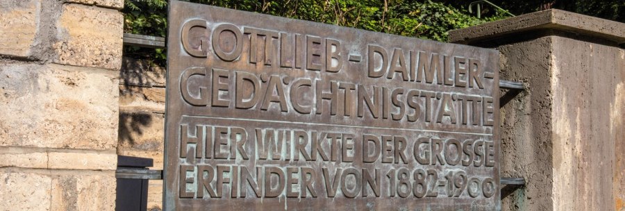 Metal sign on a stone wall with the inscription 'Gottlieb Daimler Memorial Site'. Surrounded by green vegetation., &copy; Stuttgart-Marketing GmbH Achim Mende