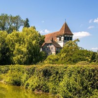 A picturesque lake in Murrhardt City Park, surrounded by lush vegetation and with a half-timbered house in the background, on a sunny day., &copy; SMG Stuttgart Marketing GmbH - Sarah Schmid