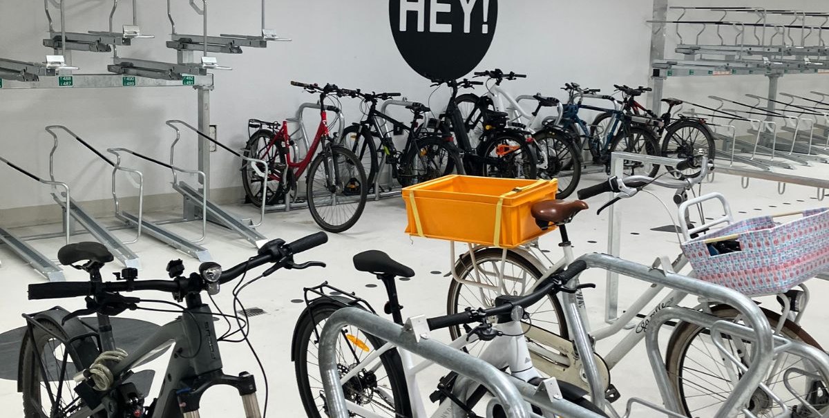 Bicycle parking garage with parked bicycles and a "HEY!" sign on the wall., © Stadt Esslingen am Neckar