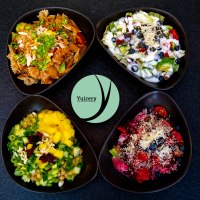 Four bowls with colorful salads and ingredients, including pasta, fruit and vegetables, on a black background. Yucery" logo in the center., © Yuicery Four bowls with colorful salads and ingredients, including pasta, fruit and vegetables, on a black background. Yucery" logo in the center., © Yuicery