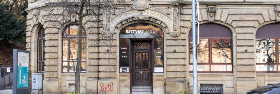 Ein historisches Gebäude mit dem Schriftzug 'Brother Louis' über der Eingangstür. Die Fassade ist aus Stein mit dekorativen Elementen., © Stuttgart-Marketing GmbH, Sarah Schmid Ein historisches Gebäude mit dem Schriftzug 'Brother Louis' über der Eingangstür. Die Fassade ist aus Stein mit dekorativen Elementen., © Stuttgart-Marketing GmbH, Sarah Schmid