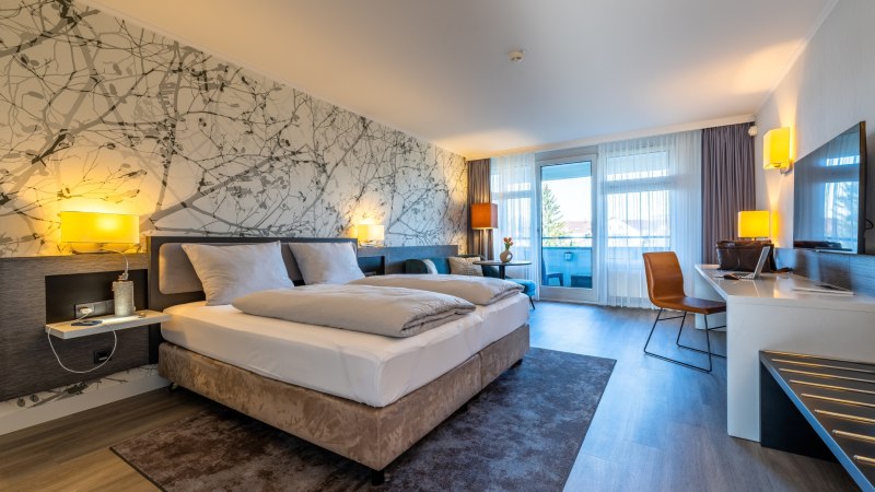 Modern hotel room with double bed, desk, chair and balcony. Light colors and stylish wall design with nature motif., &copy; MASEVEN Stuttgart SI-Centrum