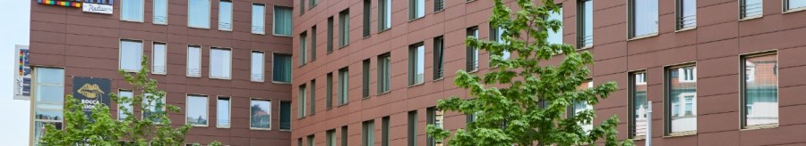 Das Park Inn by Radisson Stuttgart zeigt eine moderne Fassade mit vielen Fenstern. Vor dem Gebäude stehen grüne Bäume., © Park Inn by Radisson Stuttgart