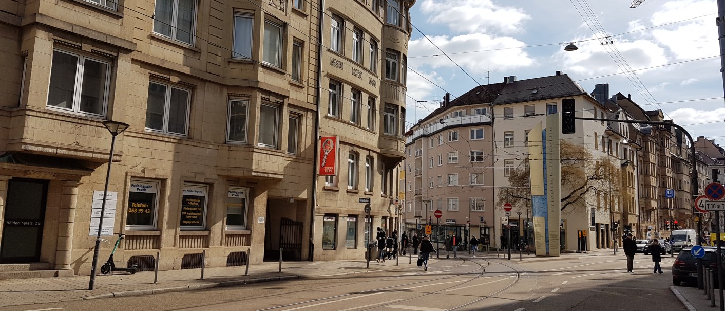 Städtische Straßenszene mit historischen Gebäuden, Straßenbahnschienen und Fußgängern. Ein E-Scooter steht an einem Laternenpfahl., © SMG Städtische Straßenszene mit historischen Gebäuden, Straßenbahnschienen und Fußgängern. Ein E-Scooter steht an einem Laternenpfahl., © SMG