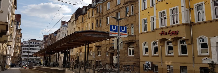 Streetcar stop in an urban street, surrounded by old buildings. A restaurant called Ha Long can be seen., &copy; SMG