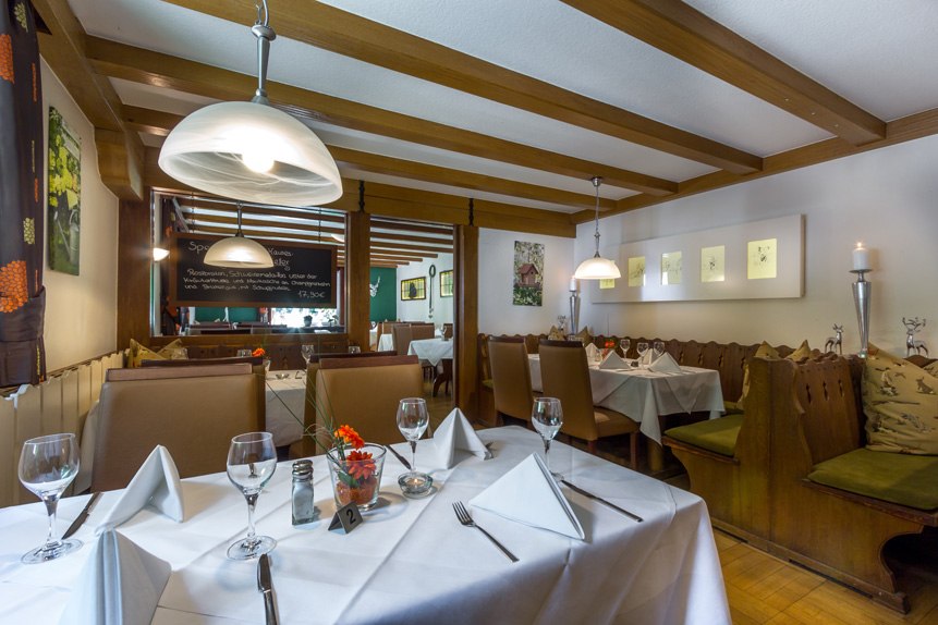 A cozy restaurant with wooden beams, set tables, and decorative elements. White tablecloths and glasses create a welcoming atmosphere., &copy; Kulinarium an der Glems