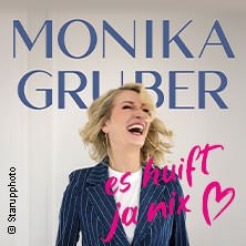 Laughing woman in striped suit, lettering 'Monika Gruber - es huift ja nix' in the background., © links im Bild Laughing woman in striped suit, lettering 'Monika Gruber - es huift ja nix' in the background., © links im Bild