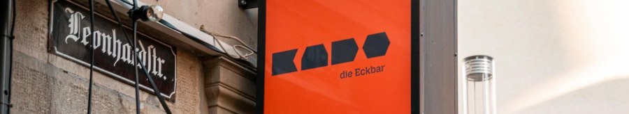 A bright orange sign reading 'Kado die Eckbar' hangs on the wall of a building in Leonhardstraße., © Stuttgart-Marketing GmbH, Sarah Schmid A bright orange sign reading 'Kado die Eckbar' hangs on the wall of a building in Leonhardstraße., © Stuttgart-Marketing GmbH, Sarah Schmid