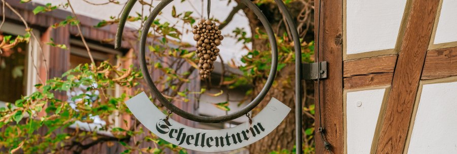 Ein Schild mit der Aufschrift 'Schellenturm' h&auml;ngt an einem Fachwerkgeb&auml;ude, umgeben von gr&uuml;nen Bl&auml;ttern., &copy; &copy; Stuttgart-Marketing GmbH, Thomas Niederm&uuml;ller