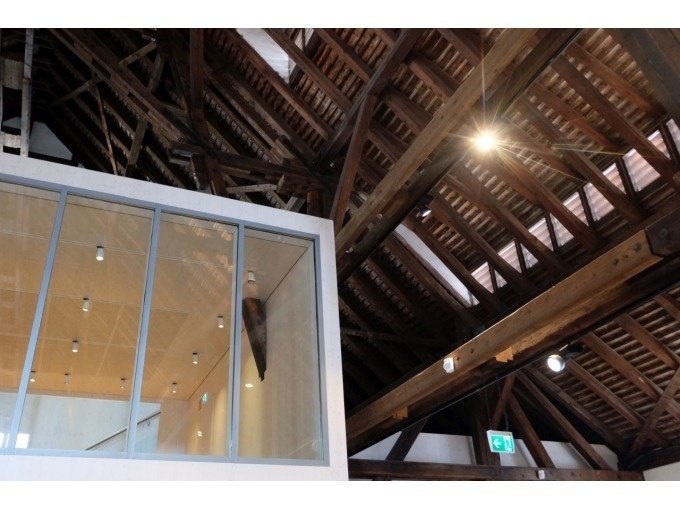 Holzdachkonstruktion mit Glaswand im Weinbaumuseum. Moderne Beleuchtung und Notausgangsschild sichtbar., © Stuttgart Marketing GmbH Holzdachkonstruktion mit Glaswand im Weinbaumuseum. Moderne Beleuchtung und Notausgangsschild sichtbar., © Stuttgart Marketing GmbH