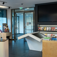 Tourist Information Center in the Stuttgart TV Tower, featuring brochures, souvenirs, and a large screen. Modern design with informational materials about the Stuttgart region., &copy; Stuttgart-Marketing GmbH, Sarah Schmid